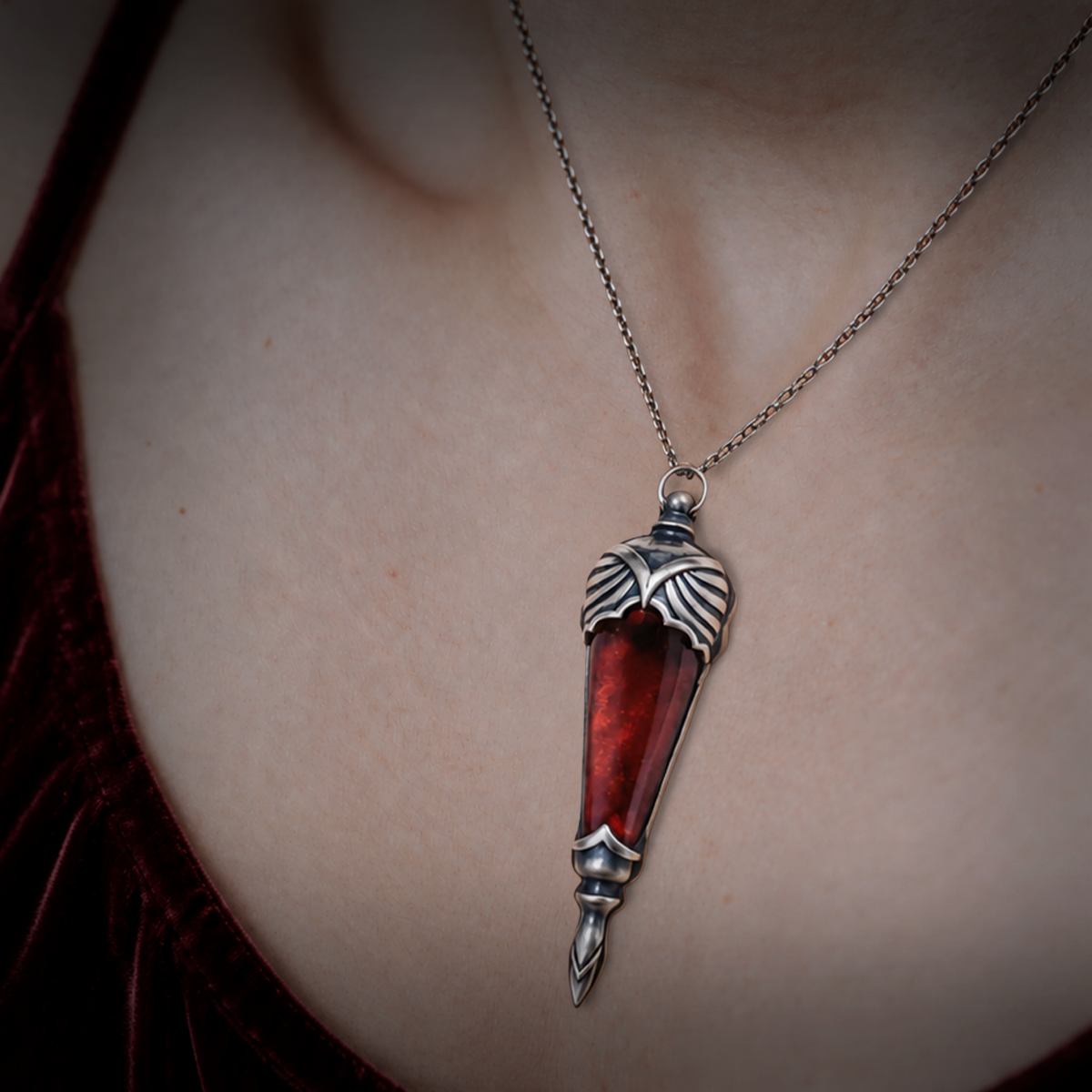 World of Darkness The Embrace Pendant, a limited edition gothic jewelry piece featuring a deep crimson red glass teardrop center set in an ornate silver-toned brass frame, displayed in a black presentation box with red satin lining alongside a numbered Certificate of Authenticity.

